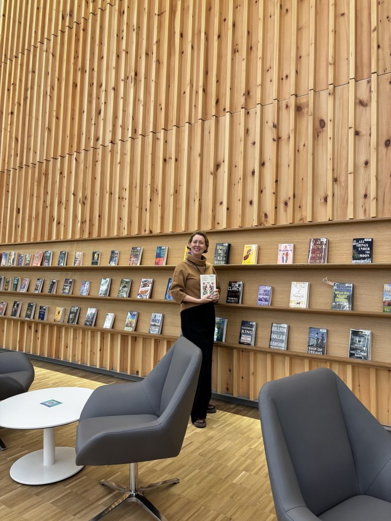 Michelle Arbuckle in front of the featured reading wall at the new Queensville Branch of East Gwillimbury Public Library.